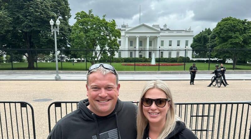 A happy man and woman taking a selfie in front of the white house in washington dc. 